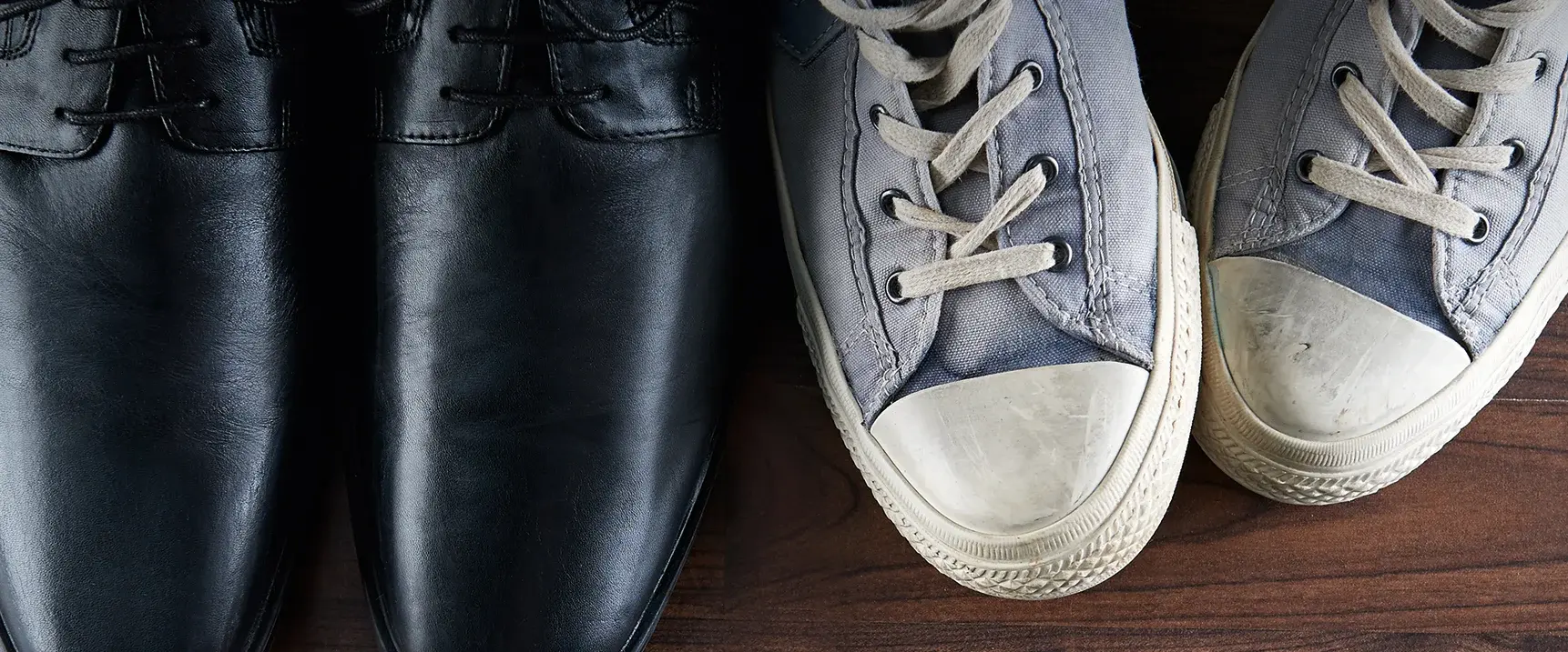 Smart suit shoes next to older Chucks